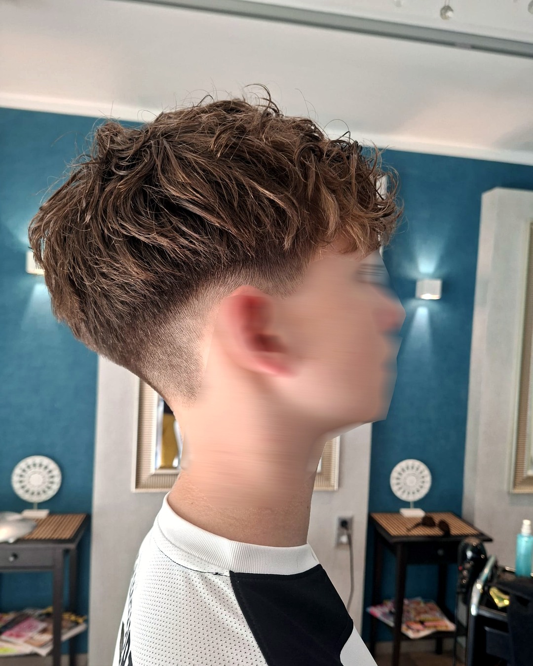 Moderner Herrenhaarschnitt mit Locken und sauberem Fade