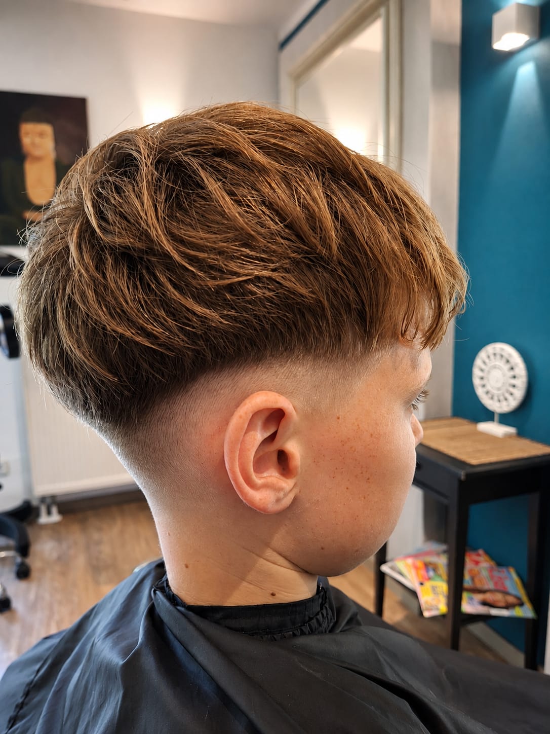 Moderner Jungenhaarschnitt mit sauberem Fade und laengerem Deckhaar